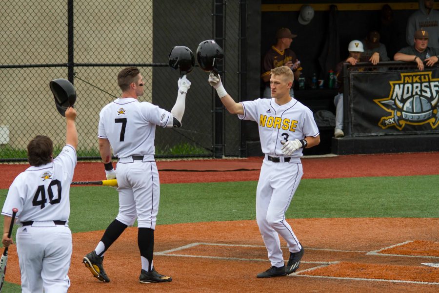 TJ Alas (7) and Ryan Mavriplis (40) congratulate Jake Richmond after Richmond hit a home run.