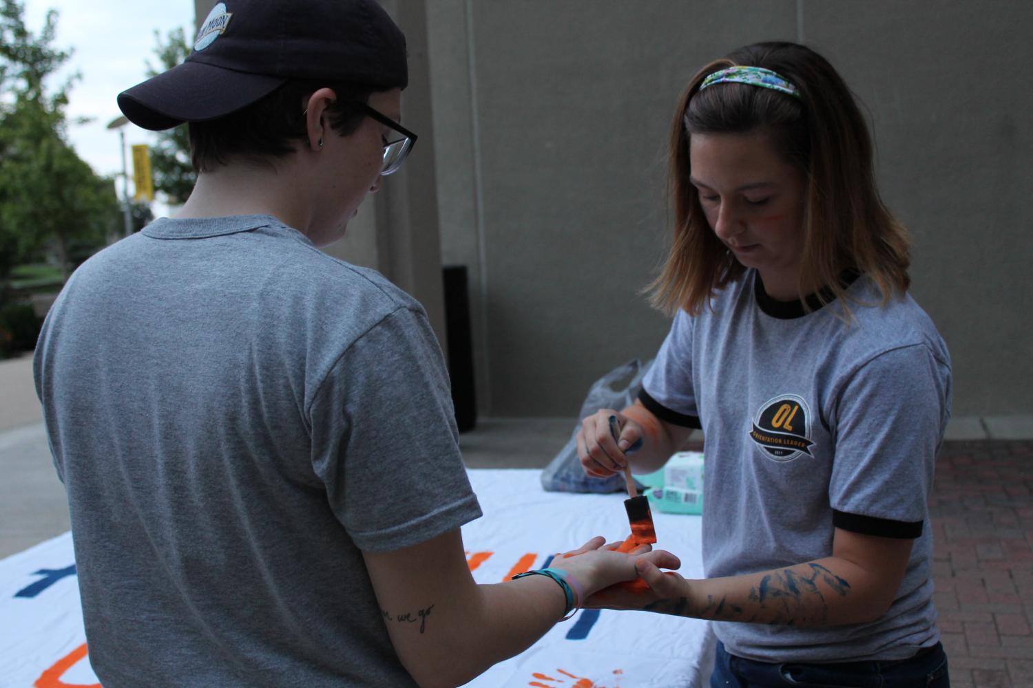 Edelen paints Victor Rices hand, a student at NKU. 