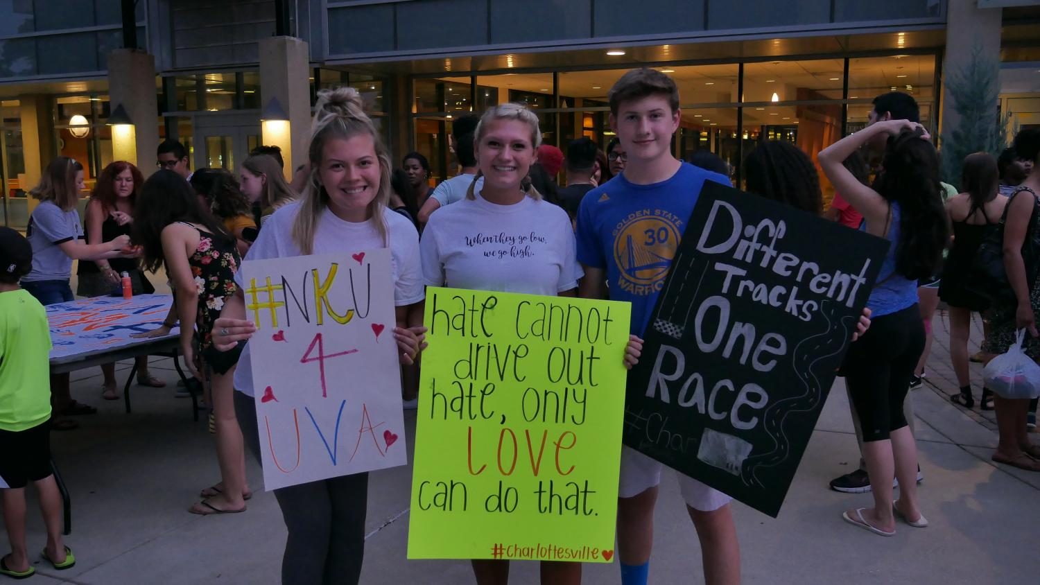 Siblings Jessica, Kelly and Ben Coburn came to vigil with signs marked in words of unity and love. 