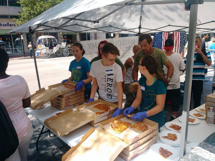 Volunteers help Maslow's Army distribute pizza on Fountain Square