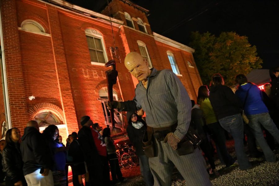 Wrench in hand, the Dent Schoolhouse's infamous Charlie the Janitor patrols lines of visitors waiting to enter.
