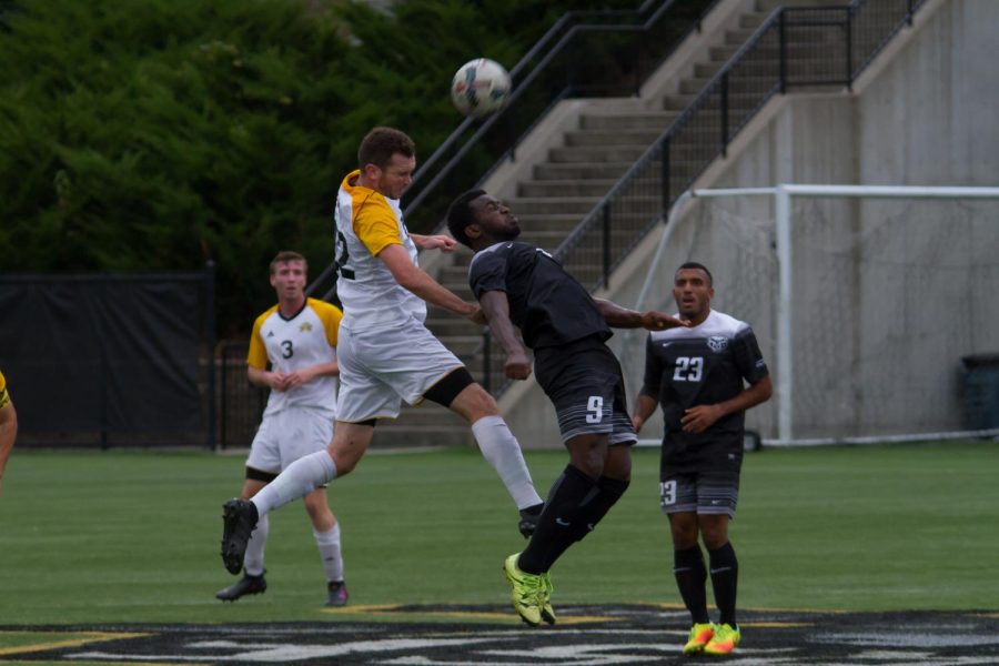 Liam Evans (22) goes up for a head in the game against Oakland