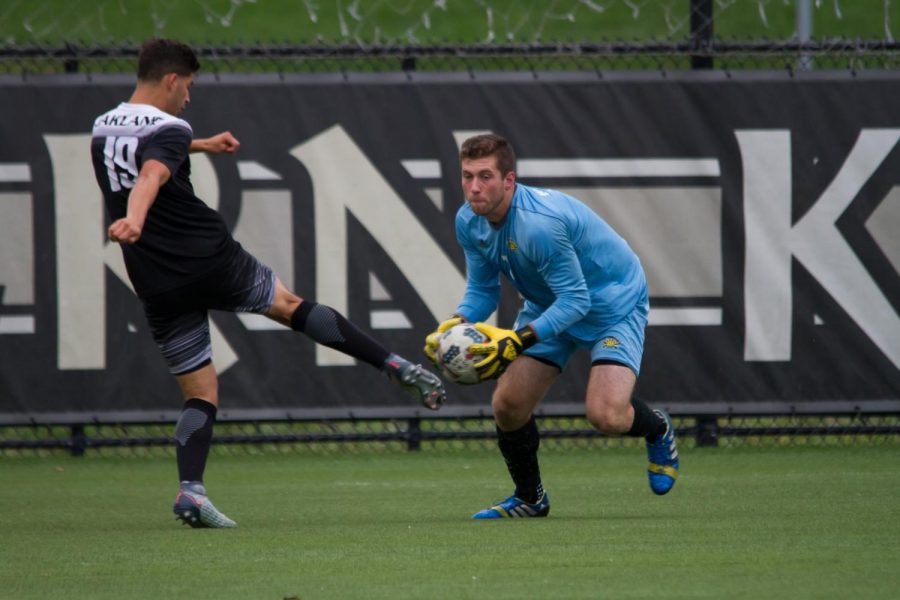 Jim Barkei (1) scoops up the ball in the game against Oakland