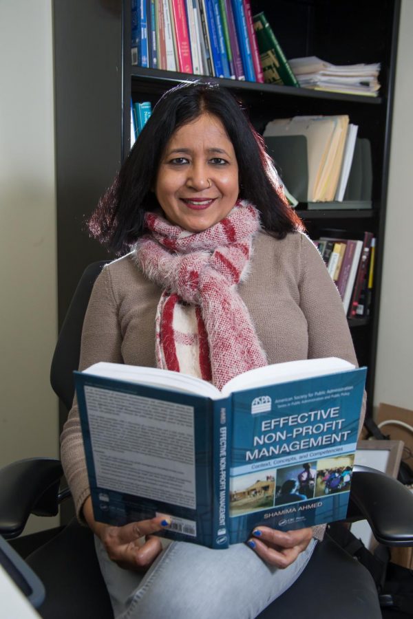 Ahmed, new member of the Fulbright Specialist program, sits with one of her published works