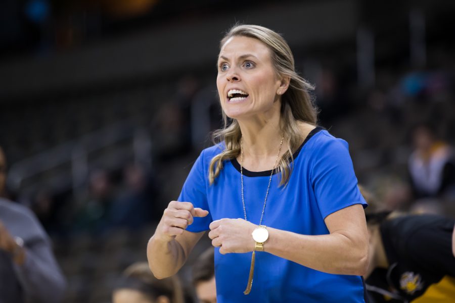 Head Coach Camryn Whitaker talks to her team during the game against Green Bay.