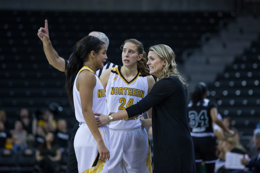 Grace White (1) and Molly Glick (24) talk to Head Coach Camryn Whitaker during a free throw in the game against Cleveland State.