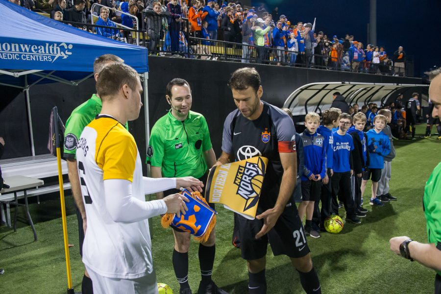 Bastian Beckers (6) exchanges flags with a the FC Cincinnati captain before the game.