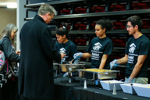 Members of Habitat for Humanity serve food at the dinner.