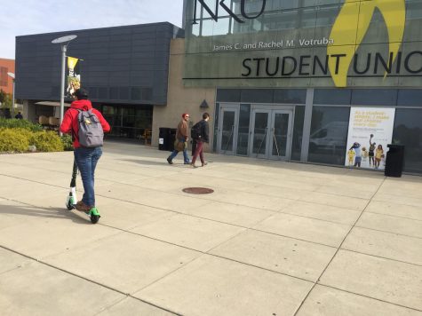 Evan Lozier, senior business managment major, test rides the scooter outside the Student Union.