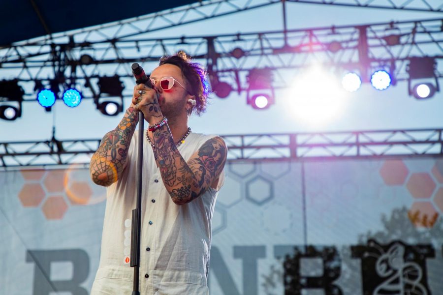 Lead singer Mitchy Collins of lovelytheband sports a white jumpsuit and red-tinted sunglasses at Bunbury Music Festival.