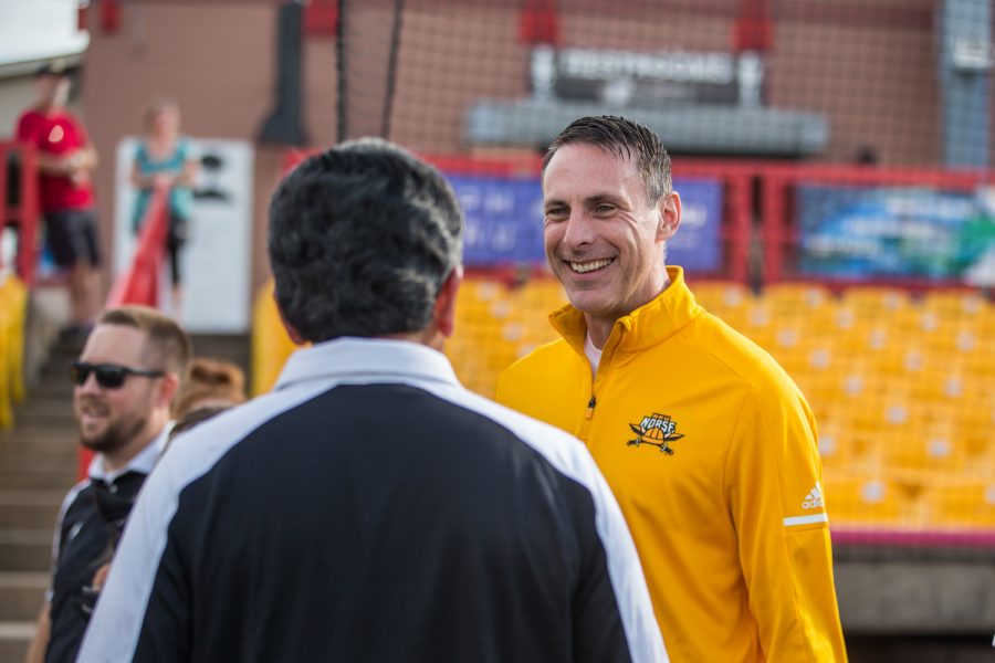 Men's Basketball Head Coach Darrin Horn (right) talks with NKU President Ashish Vaidya (left) prior to the first pitch at the Florence Freedom Baseball Game.