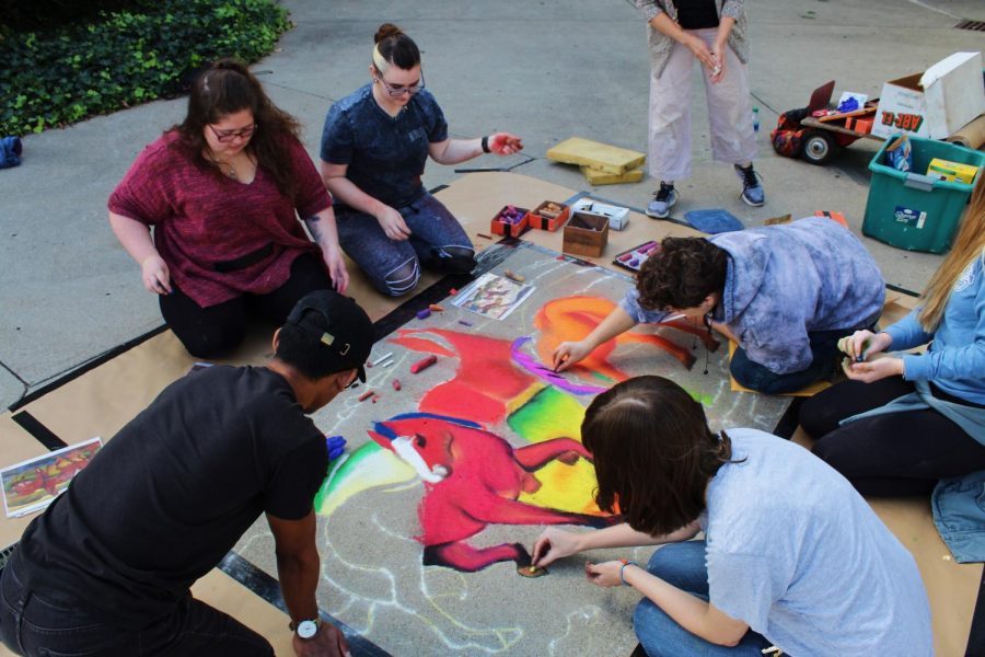 Students painting The Red Horses with chalk.