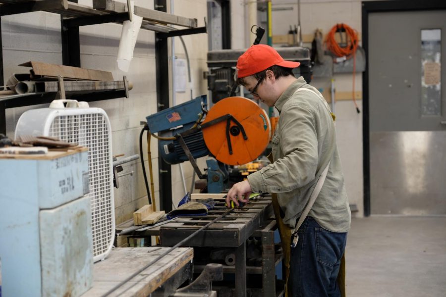 New media art major Zack Hargrove cuts away at a piece of metal for use in "Light Streams".