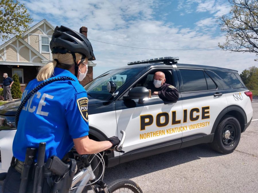 Officer Dewayne Cox (in car) and Officer Autumn Ruehl (on bike) with Detective Bobby Pate in the background.