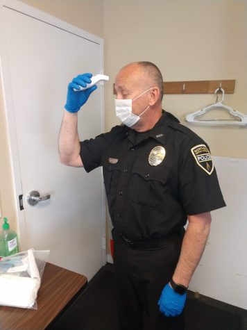 Officer Dewayne Cox taking his own temperature. Before reporting for duty, each officer has their temperature taken to ensure they are not experiencing any symptoms.