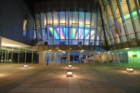 Griffin Hall at night. Its dark outside and there are bright color lights.