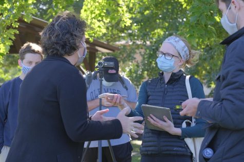 Amy McGrath stands on the left talking with Editor-in-Chief Natalie Hamren on the right. Hamren is holding her phone to record McGrath. 