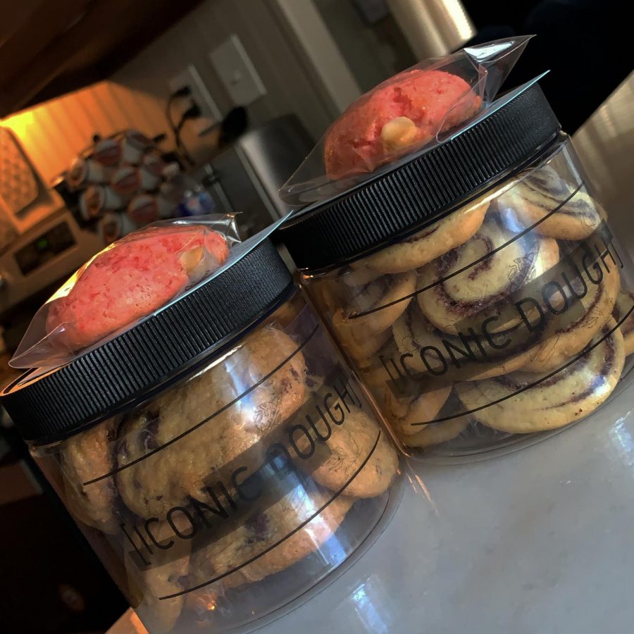 Two jars of cookies filled with chocolate chip, cinnamon roll and more.