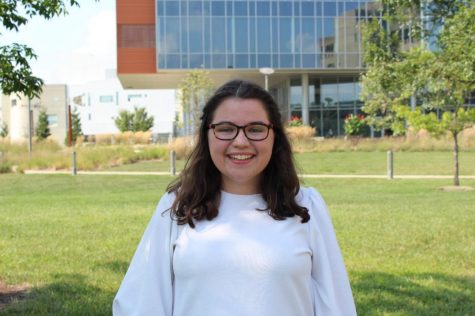 Hannah Miller wearing a white blouse smiling at the camera. 