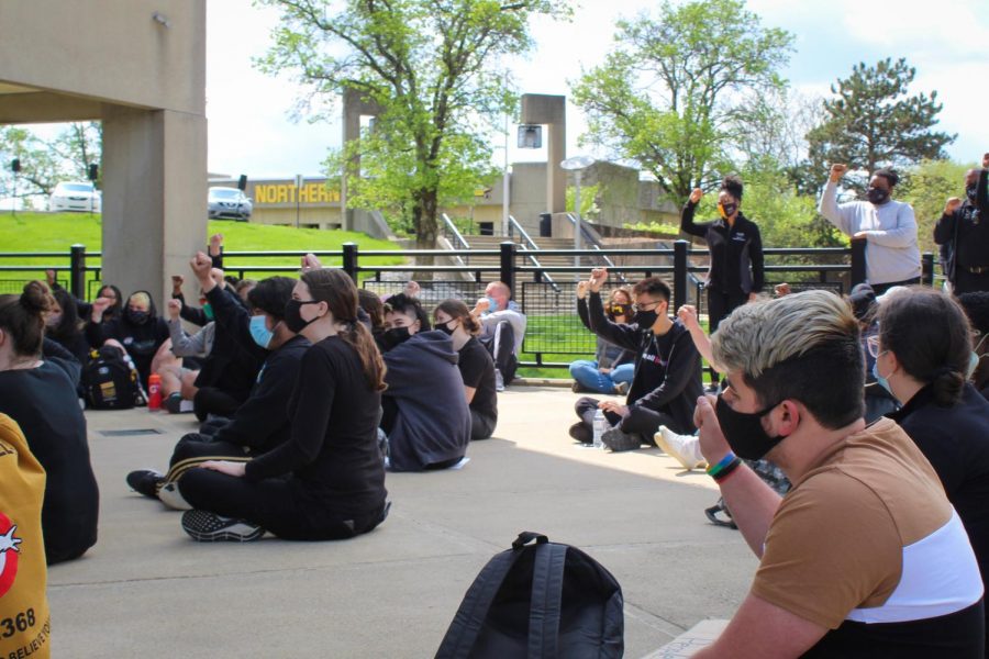 Students raise their right hands in protest outside the Lucas Administration Center.