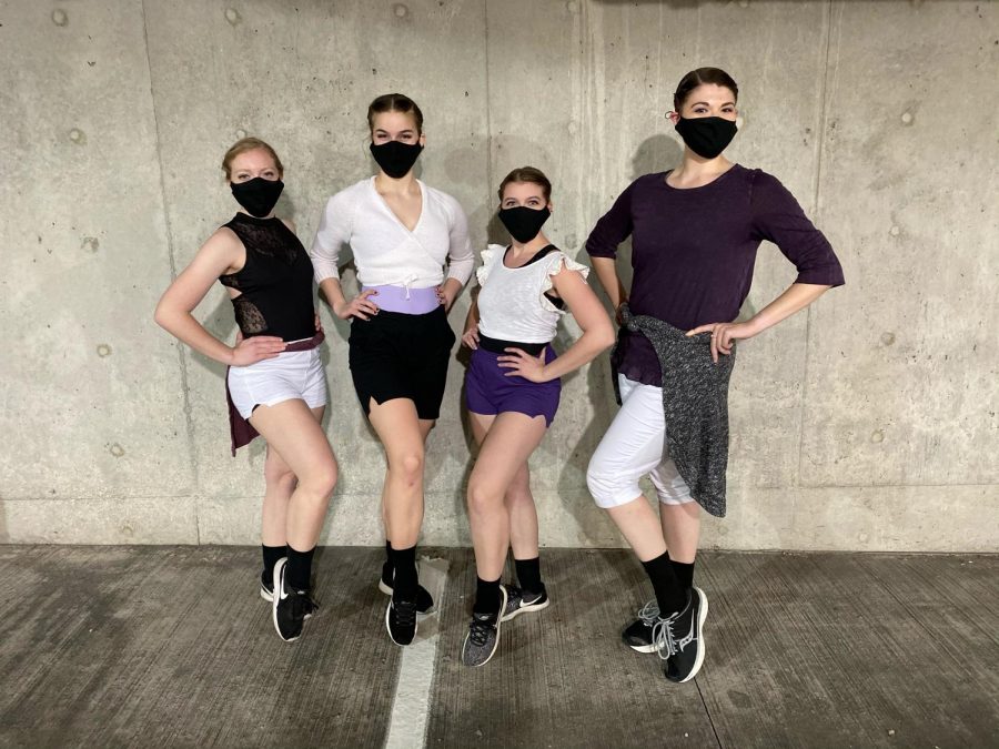 Four dancers wearing face masks and popping their leg up.