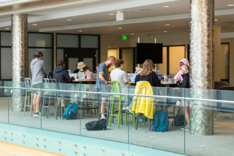 Students conversing with one another in the Student Union sitting at tables.