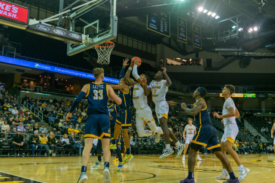 NKU forward Chris Brandon and guard Marques Warrick go up for the rebound against UNC Greensboro.