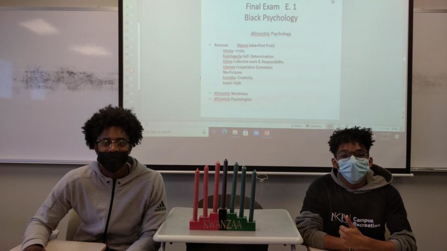 Alex Gilmore (left) and Miles Johnson (right) pose with Kwanzaa candles.