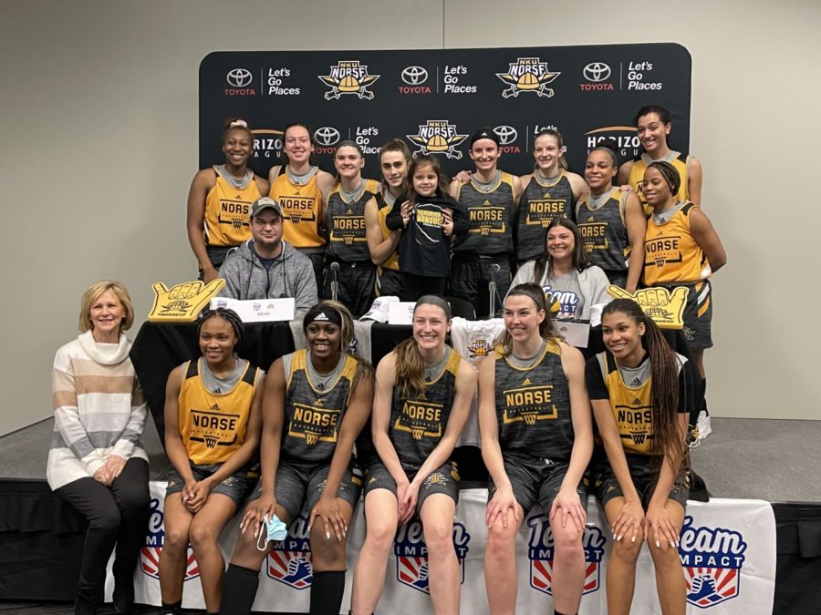 The NKU women's basketball team gathers for a picture with six-year-old Caroline Gross, who has joined the team through a partnership with Team IMPACT.