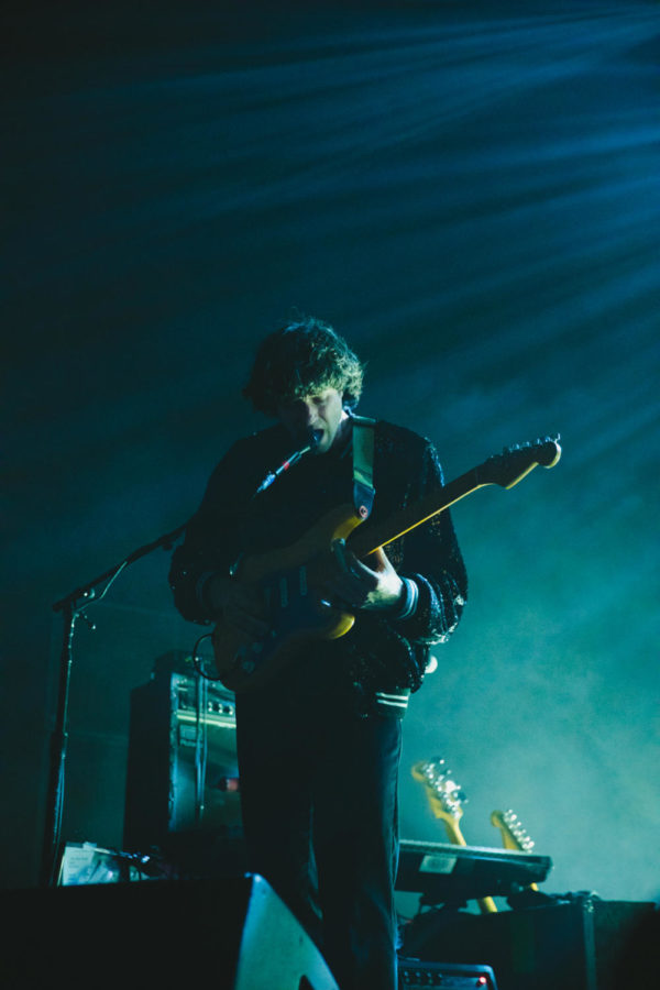 Alex Scally, guitarist for Beach House, interacts with the fans as he strums his instrument.