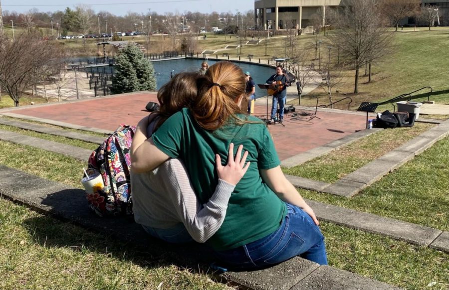 Two friends sharing a hug at the campus concert.