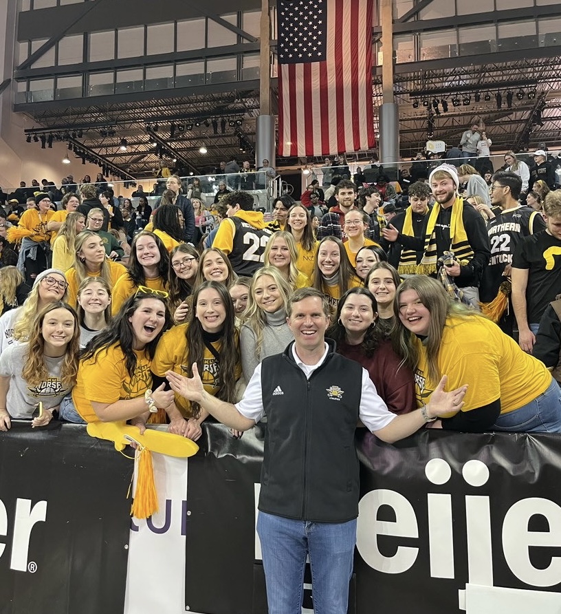 Members of Theta Phi sorority and other students pose with the governor at the basketball game.