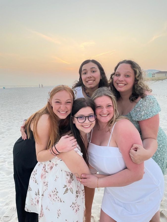 Reagen Bass (lower right) embraces friends on the shores of Alabama.