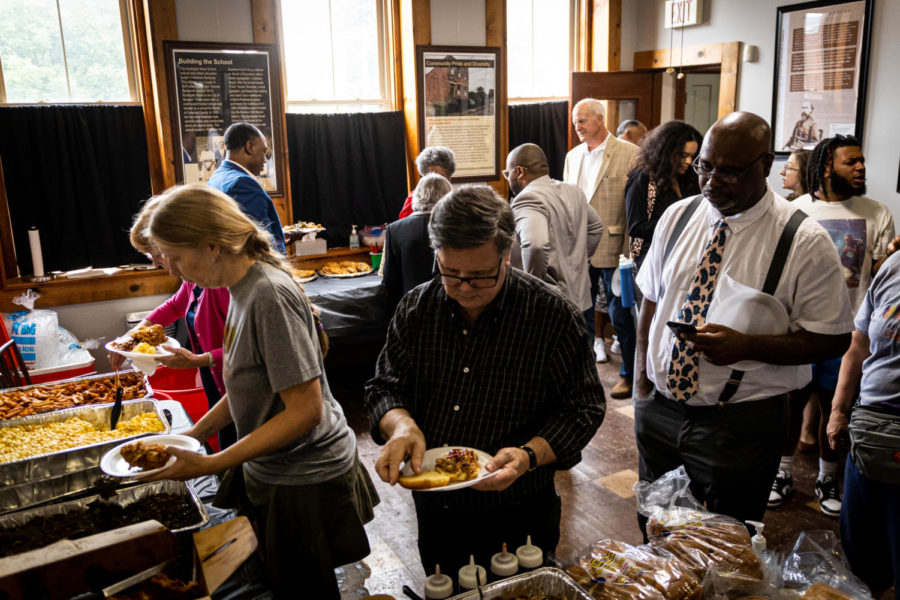 Guests at Newports Juneteenth celebration piled plates high with food inside Southgate Street School. NKU Masters in Public History students Juneteenth exhibit was displayed in frames around the room.