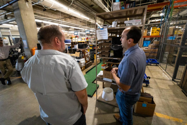 Andrews (left) and Baird (right) chatting in the Surplus Property warehouse.