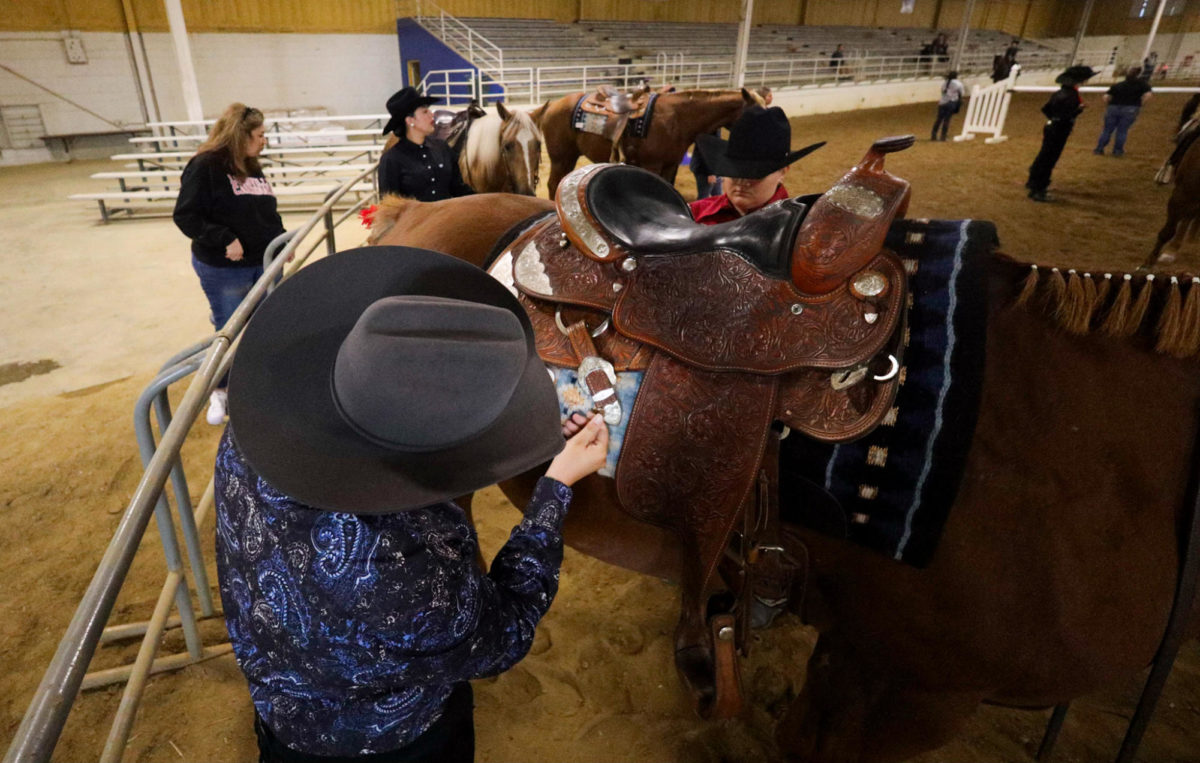 Aj Allen, a senior at NKU, pins their number onto the saddle before competing.