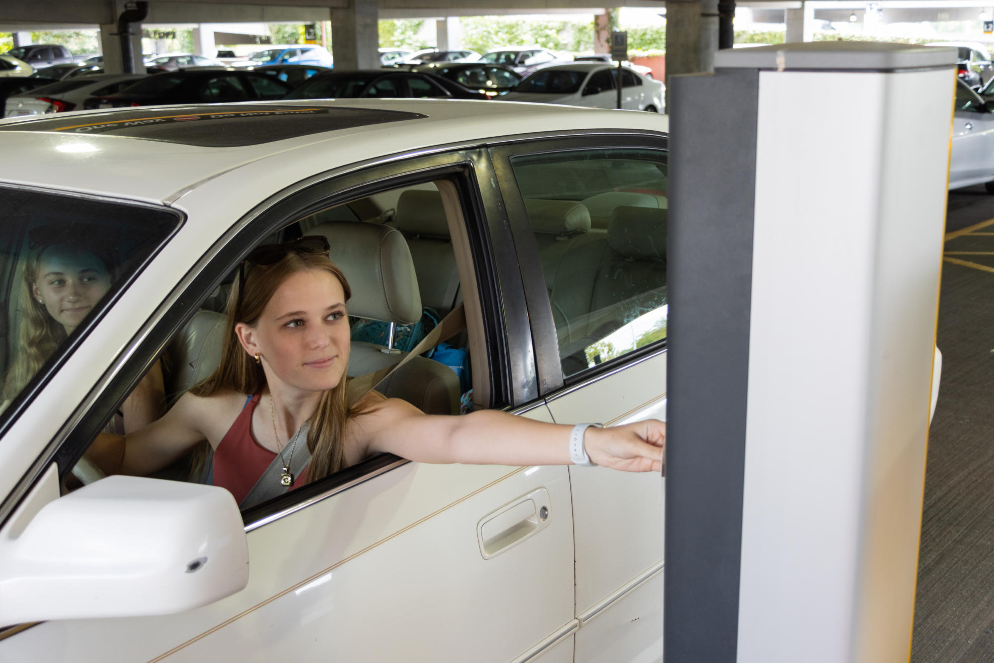A student scans her parking permit before exiting the Kenton Garage.