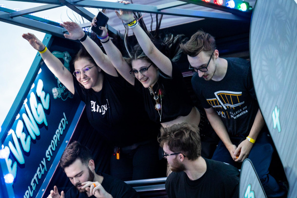 Students throw their hands in the air while on the "Phantom" swinging carnival ride.
