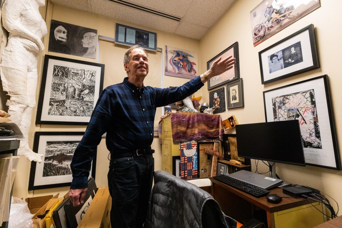 Dr. Robert Wallace in his office, surrounded by artworks created by his students.