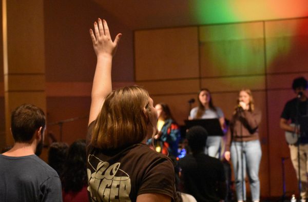 Madison Fulton, from Delight Ministries, raises her hand in worship.