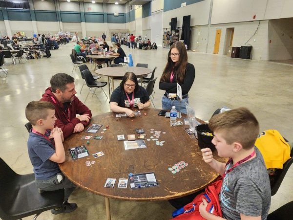 Christy Hoots (center) plays Knockout High at a game convention. (Provided)