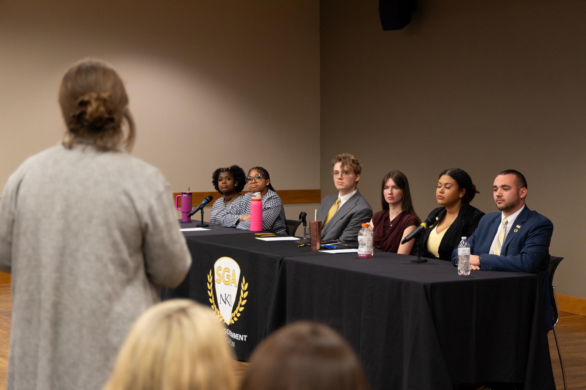 Candidates look on as an audience member asks a question at Monday night's debate.