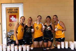 The women's basketball team handing out ice-cream at the Scoops and Hoops events.  