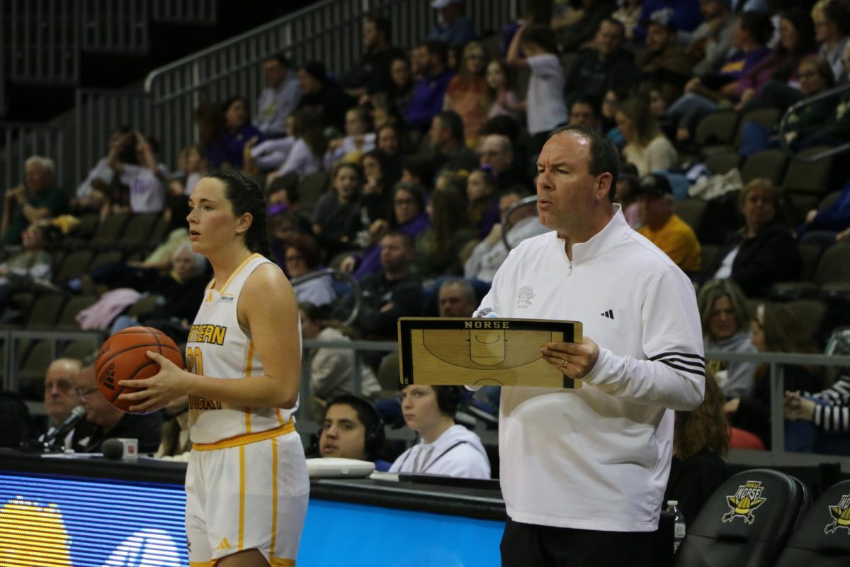 Macey Blevins (left) about to throw in the ball and Jeff Hans (right) drawing and yelling out a play for his team.