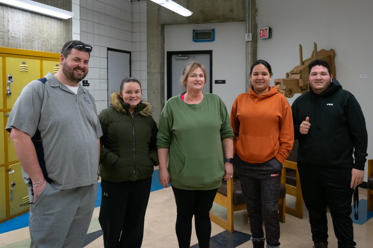 A group of custodians pause in their cleaning efforts to take a group photo.